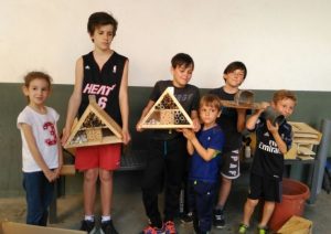 Grupo de niños mostrando orgullosos sus hoteles de insectos construidos